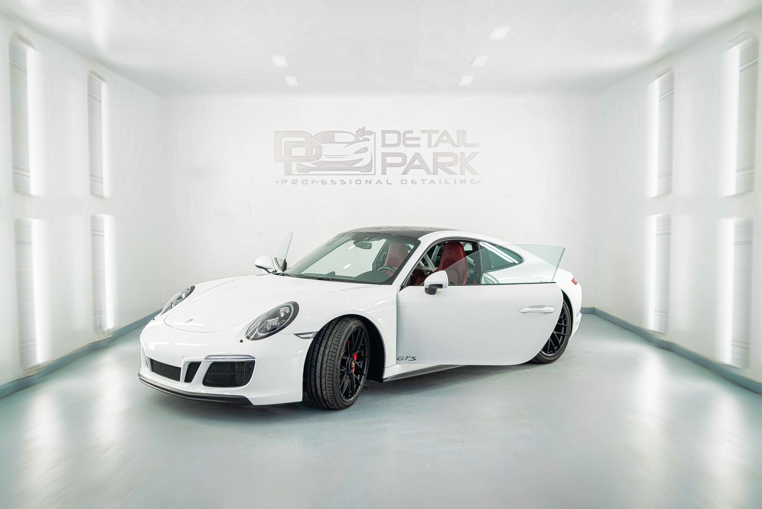 Protección de pintura para Porsche 911 Carrera GTS: chapa y PPF 9 Porsche 911 Carrera GTS blanco con la puerta abierta en el estudio de Detail Park al entregarlo