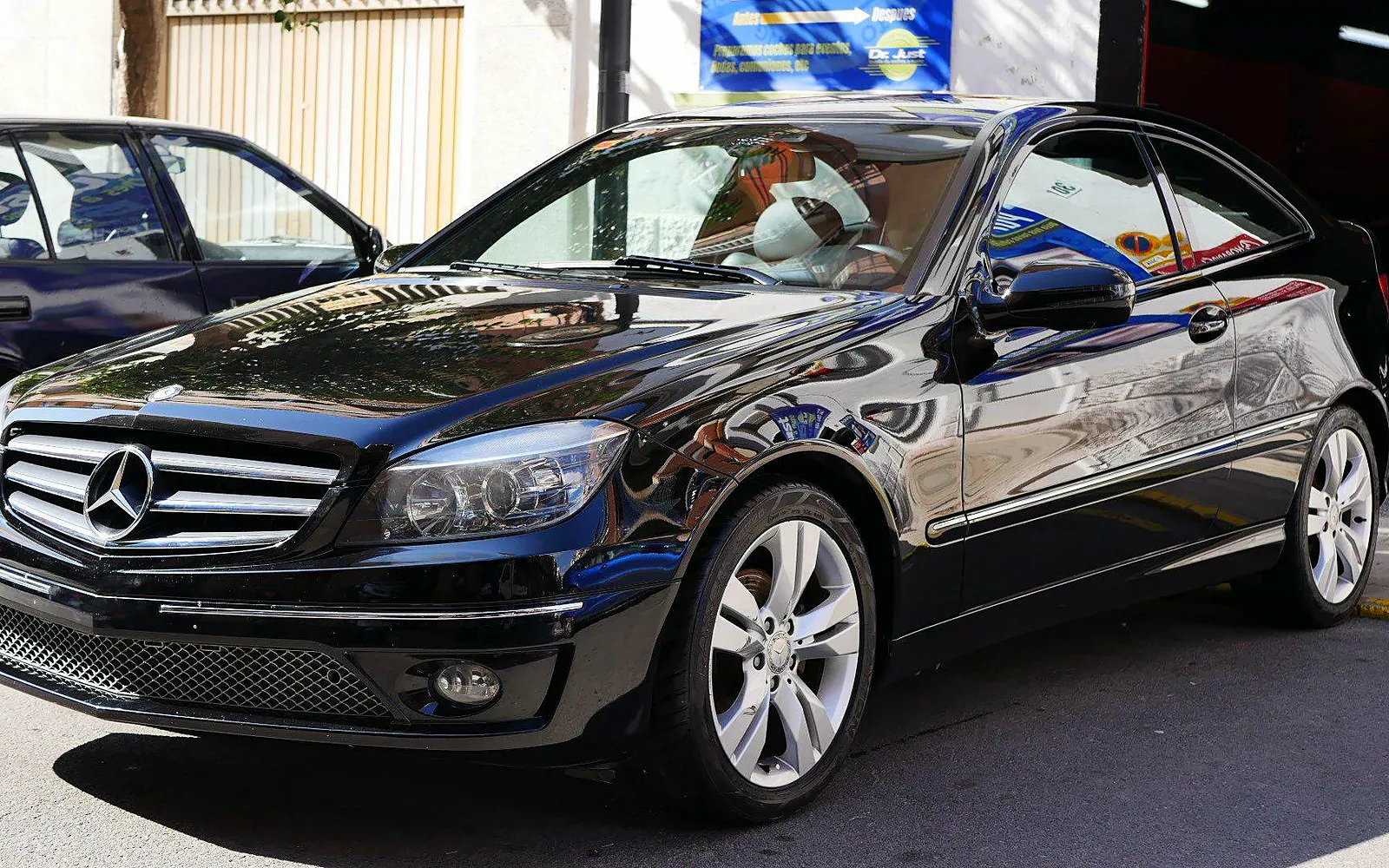 Cera de carnauba en un Mercedes CLC 200 negro, tras un pulido 1 Cera de carnauba en un Mercedes CLC 200 negro, en tres cuartos delantero con reflejos en el capó