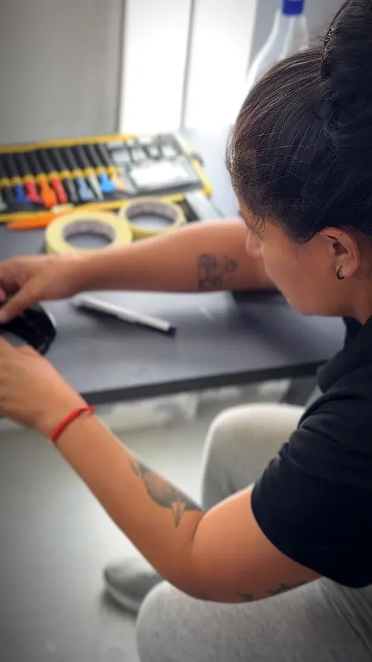 Alumna practicando la instalación de vinilo con espátula y cuchilla en el curso de car wrapping