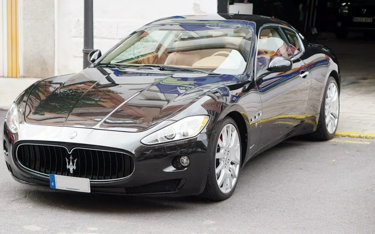 Detailing Maserati GranTurismo negro en tres cuartos delantero con la pintura pulida y tratada