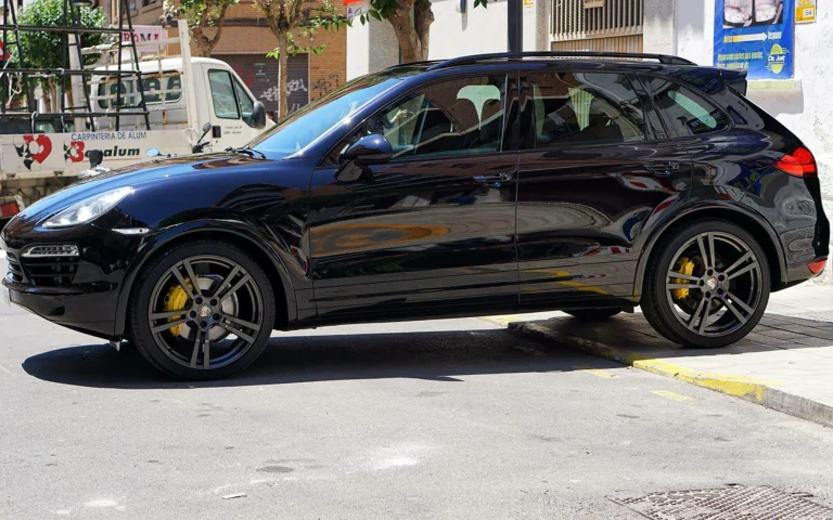 Detailing Porsche Cayenne negro de perfil con pinzas amarillas tras el pulido en dos fases