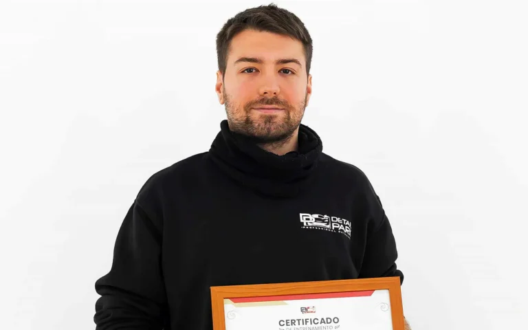 Pedro Cerdán sostiene su certificado de detailing de Detail Park ante el logotipo del taller