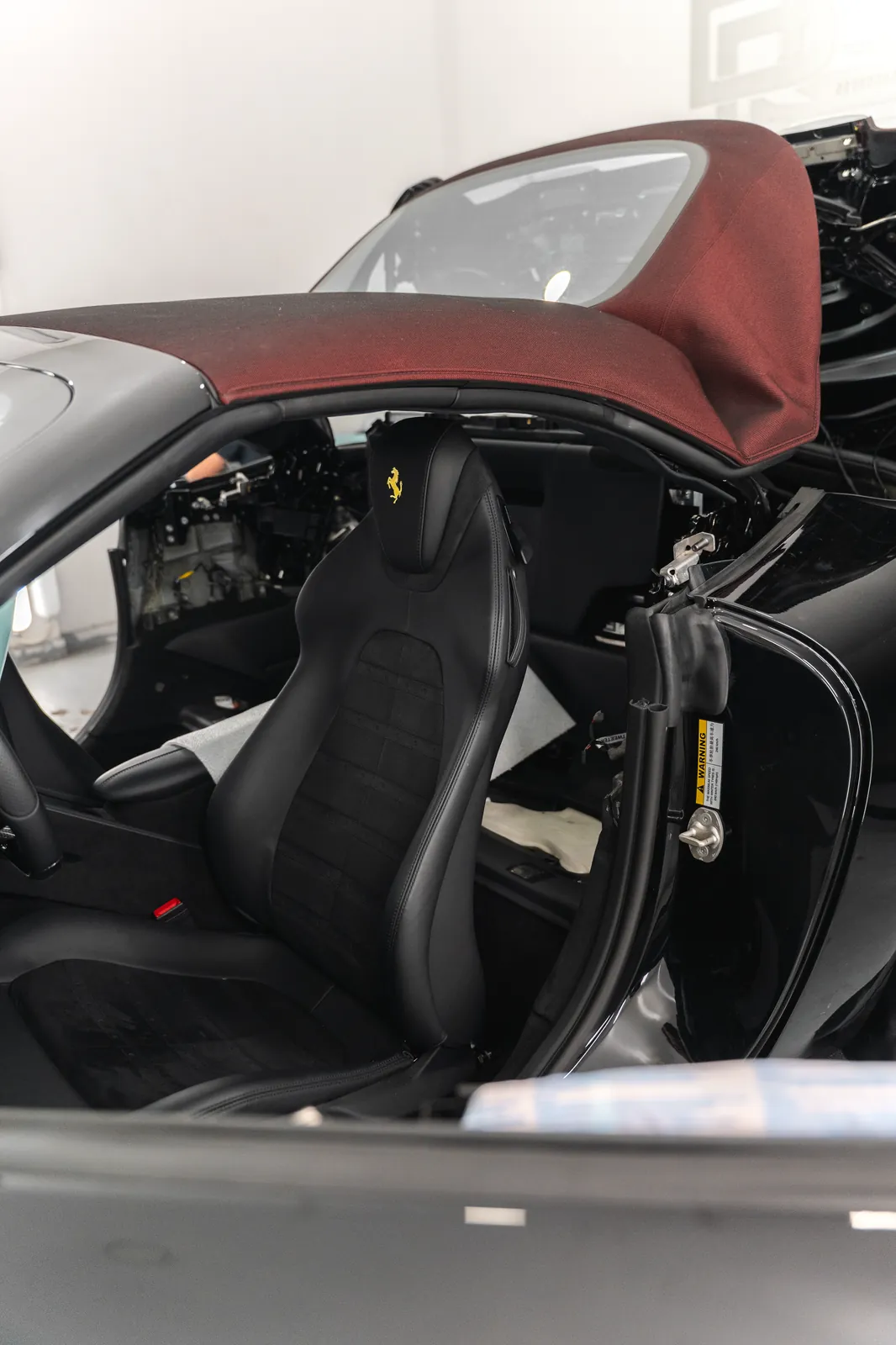 Ferrari Roma Spider: cinturones amarillos personalizados y full PPF 9 Interior del Ferrari Roma Spider con la capota abierta durante el montaje de los cinturones personalizados