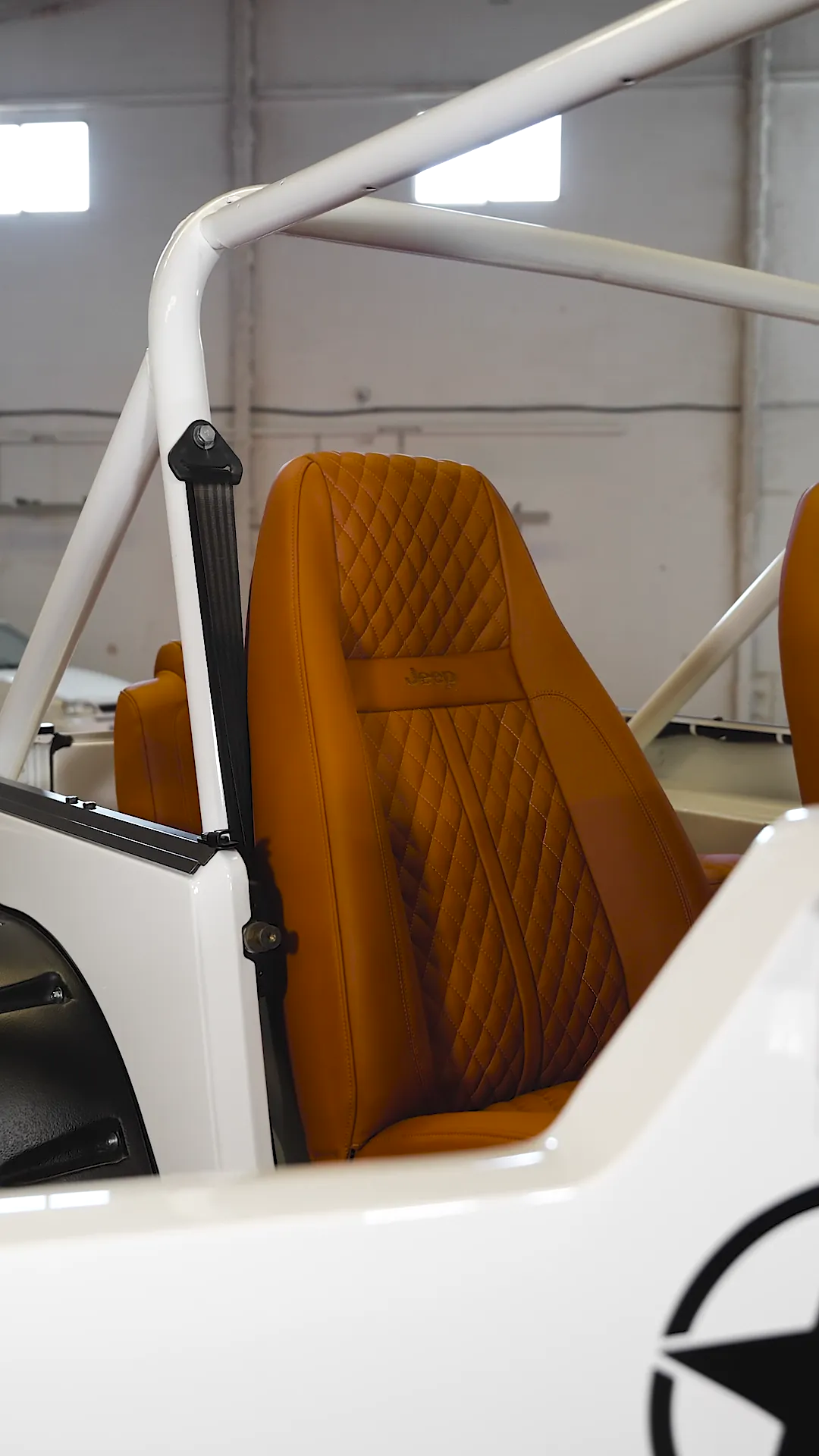 Jeep Wrangler YJ: restauración completa y tapizado a medida 28 Interior del Jeep Wrangler YJ con asientos, paneles y volante tapizados en coñac y suelo de madera