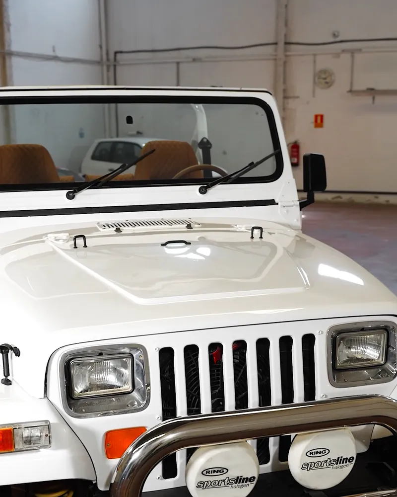 Jeep Wrangler YJ: restauración completa y tapizado a medida 6 Frontal del Jeep Wrangler YJ pintado de blanco tras la restauración
