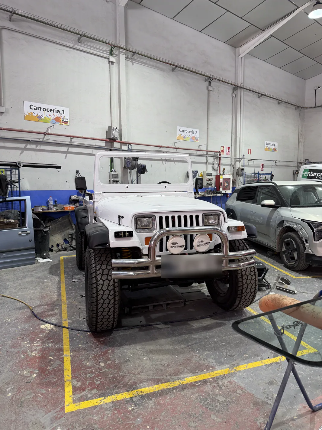 Jeep Wrangler YJ: restauración completa y tapizado a medida 7 Jeep Wrangler YJ recién pintado de blanco durante el montaje en el taller