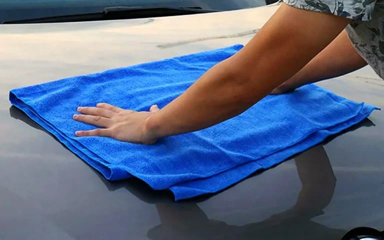 Cómo lavar el coche a mano: secado del capó con una toalla de microfibra azul sin arrastrar