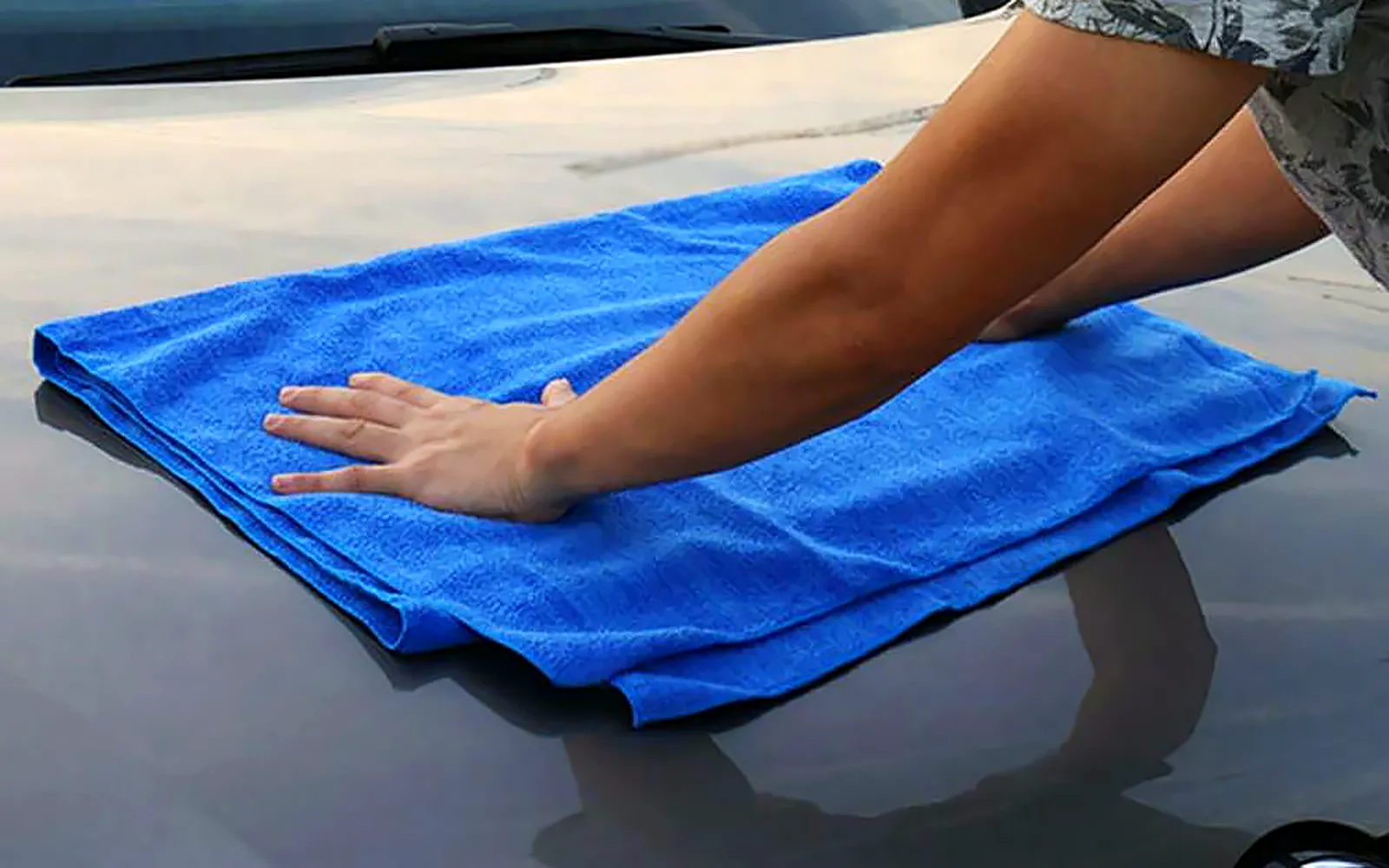Cómo lavar el coche a mano paso a paso: el método de los dos cubos 1 Cómo lavar el coche a mano: secado del capó con una toalla de microfibra azul sin arrastrar