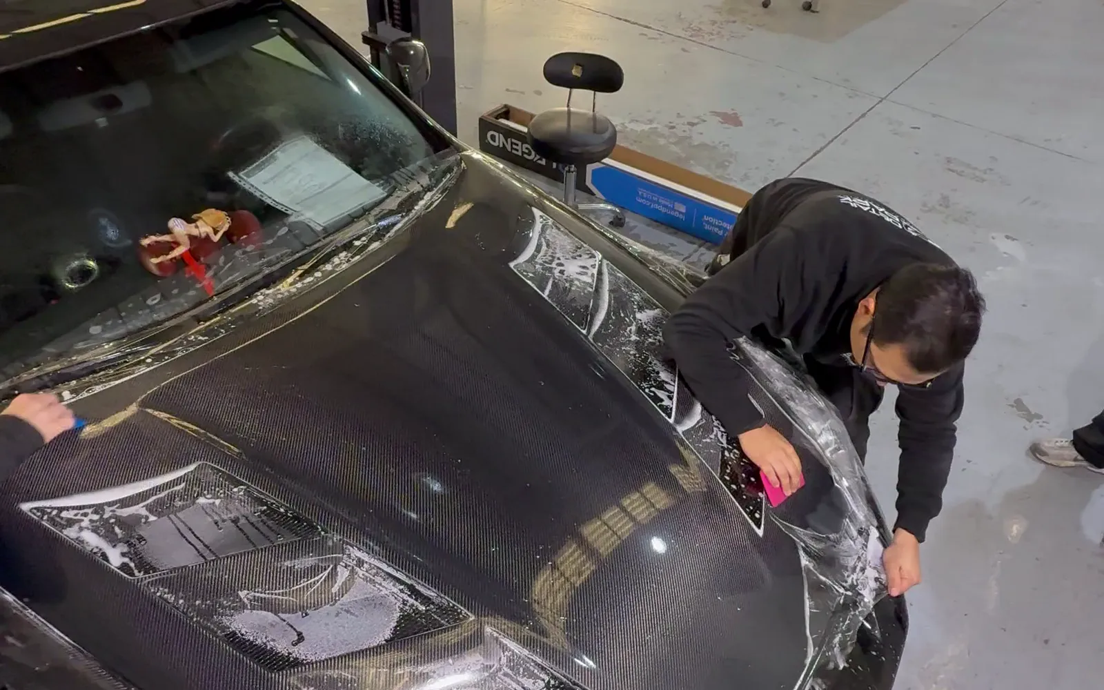 Nissan 370Z Nismo: PPF full frontal STEK para proteger su carbono 1 Técnico de Detail Park instalando PPF STEK sobre el capó de fibra de carbono de un Nissan 370Z Nismo negro