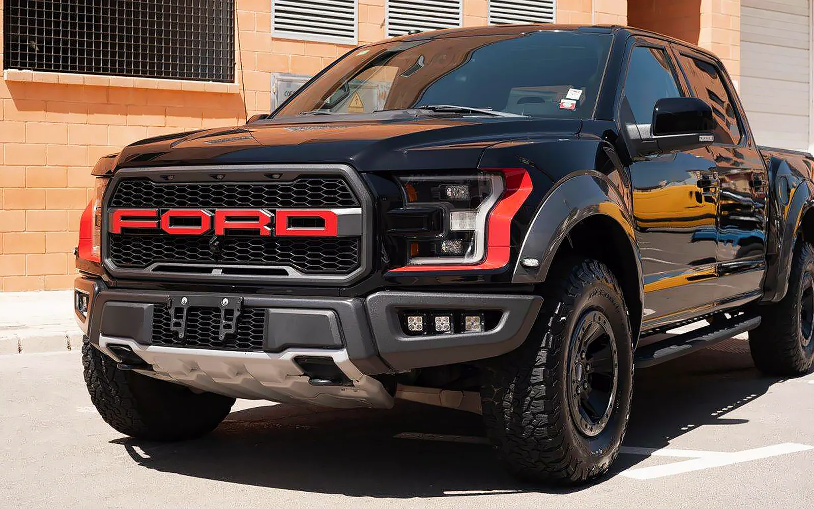 PPF Ford Raptor: STEK DYNOshield para una pickup aventurera 1 PPF Ford Raptor: pickup negra en tres cuartos delantero con la parrilla FORD en rojo