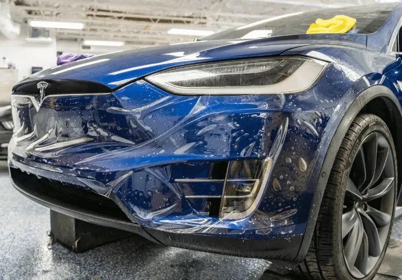 PPF para Tesla: cómo proteger la pintura de un Model 3 o Model Y 2 Frontal de un Tesla azul con la lámina de PPF recién aplicada sobre el paragolpes