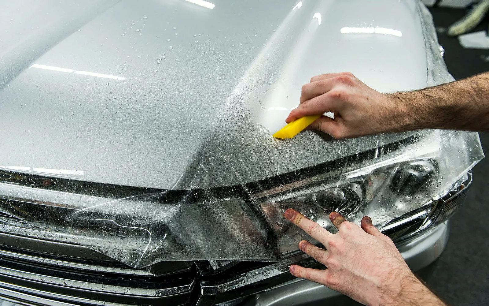 Marcas de PPF y tipos de lámina: cómo elegir el paint protection film 1 Lámina de PPF transparente aplicada en el capó y el faro: qué cambia entre marcas de PPF