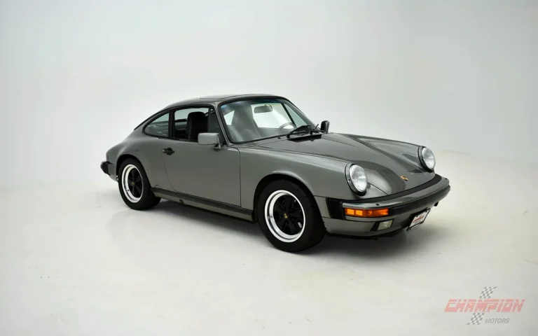 Detallado Porsche 911 clásico: Carrera gris en tres cuartos delantero sobre fondo blanco