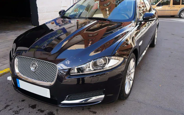 Jaguar XF negro en tres cuartos delantero tras proteger la pintura del coche con cera Swissvax