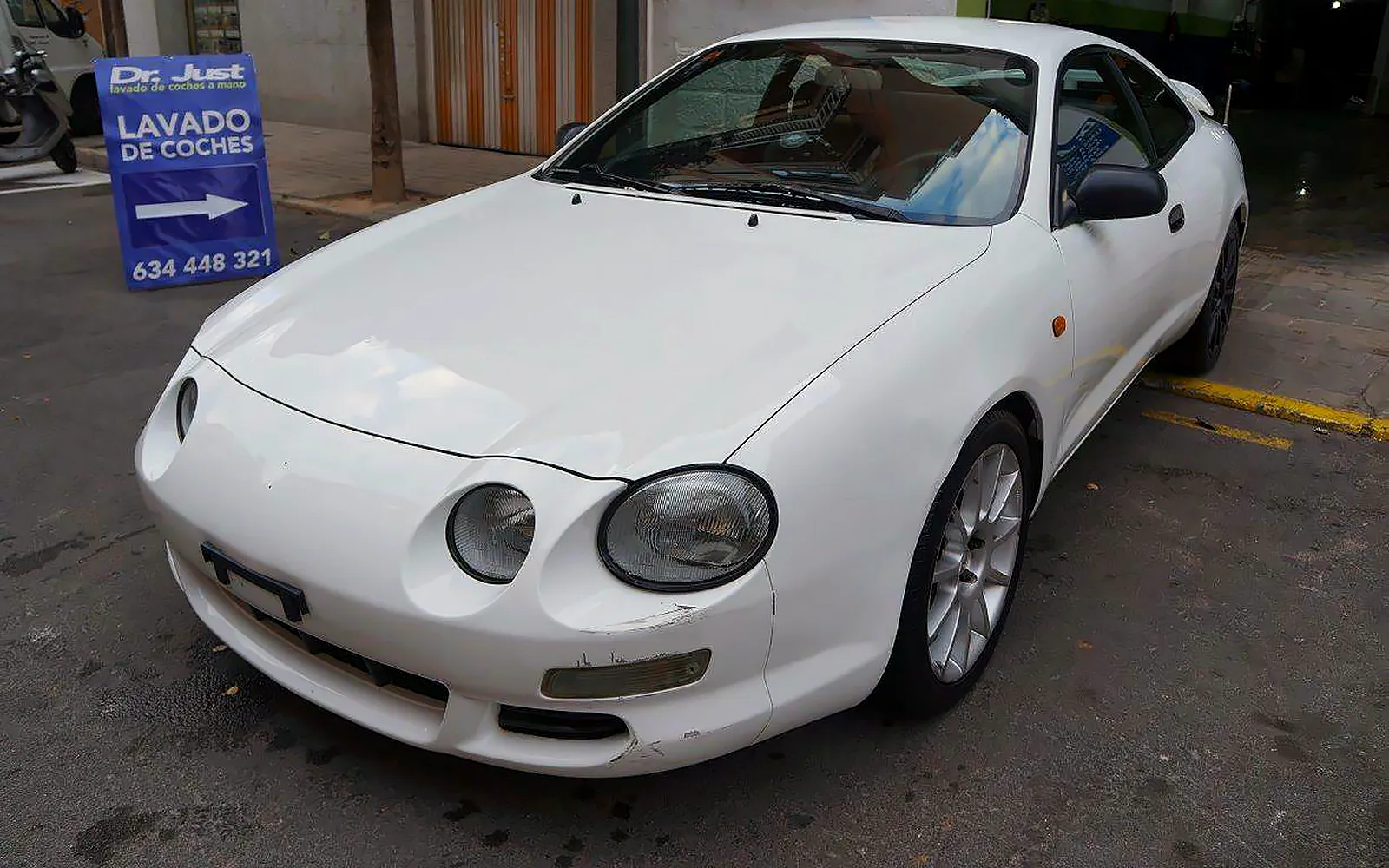Pulido de un Toyota Celica blanco: 8–10 horas para recuperar el brillo 1 Pulido del Toyota Celica blanco de cuatro faros redondos, en tres cuartos delantero tras el trabajo