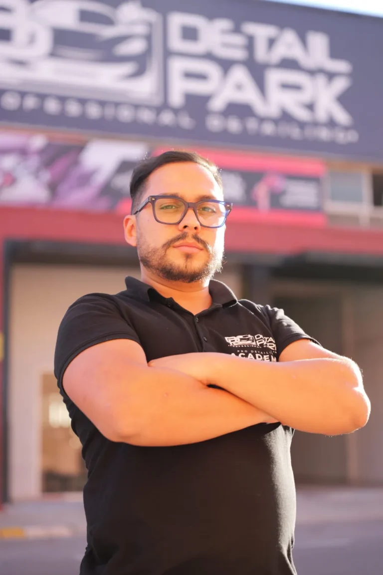 El Equipo 8 Sergio, detailer de Detail Park, con gafas y los brazos cruzados delante de la fachada del taller