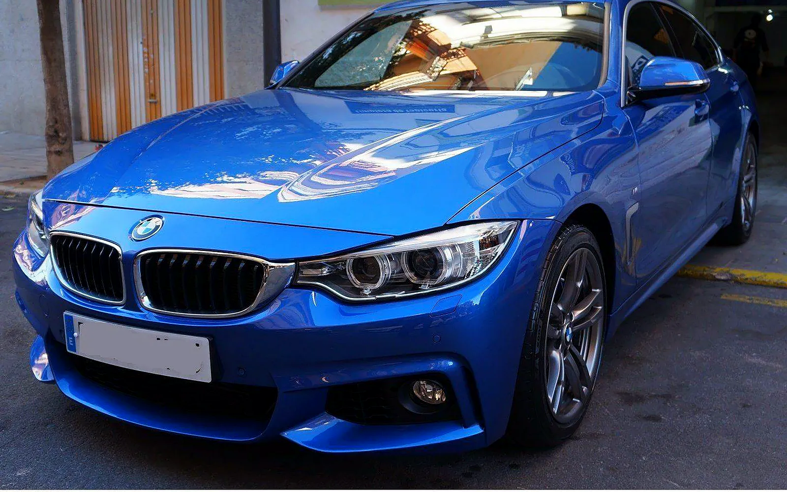 Tratamiento cerámico cQuartz en un BMW Serie 4 azul 1 BMW Serie 4 azul de frente con reflejos en el capó tras el tratamiento cerámico cQuartz