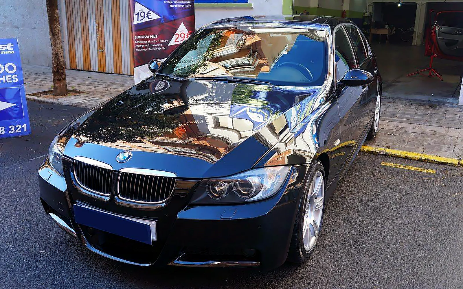 Tratamiento cerámico Gyeon en un BMW 320: proceso completo 1 BMW 320 oscuro en tres cuartos delantero con brillo de espejo tras el tratamiento cerámico Gyeon