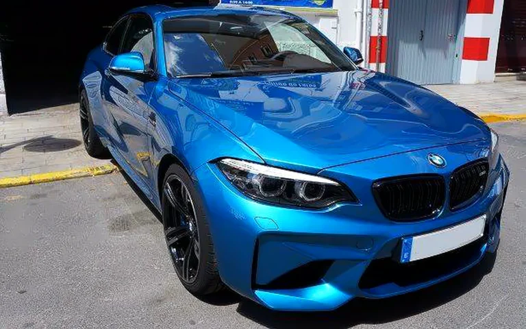 Encerado de carnauba en el BMW M2 azul, visto en tres cuartos delantero con llantas negras