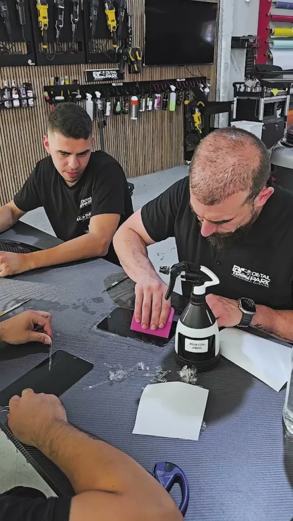 Cursos de Paint Protection Film 19 Alumnos practicando la colocación de PPF en la mesa de trabajo durante el curso