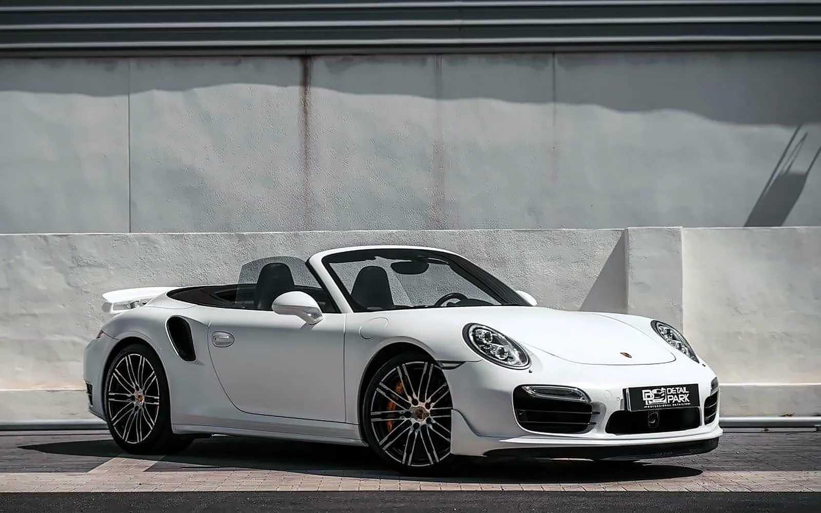 Vinilado Porsche 911 Turbo S Cabrio: personalizar y proteger 1 Vinilado Porsche 911 Turbo S Cabrio: el descapotable blanco con la capota bajada y el alerón desplegado