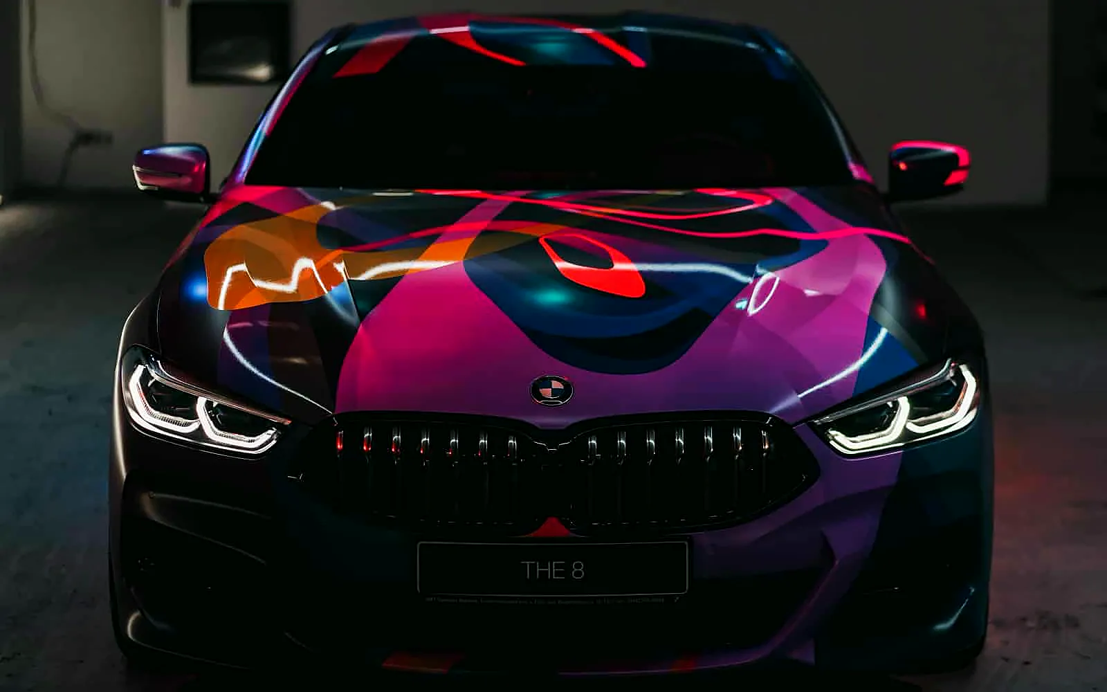 ¿Vinilar o pintar un coche? Comparativa y claves para decidir 1 BMW Serie 8 con vinilo artístico en tonos rosa, azul y naranja, ejemplo para decidir si vinilar o pintar un coche